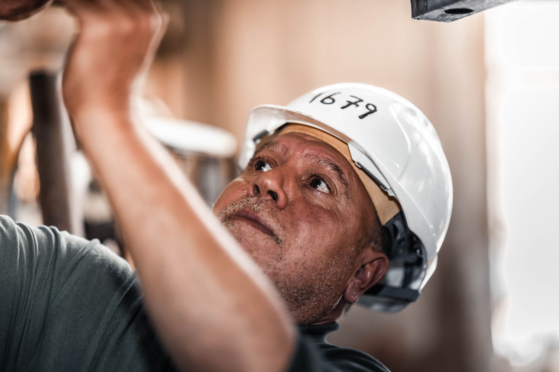 Construction worker in Libya concentrating on a task while wearing a safety helmet.