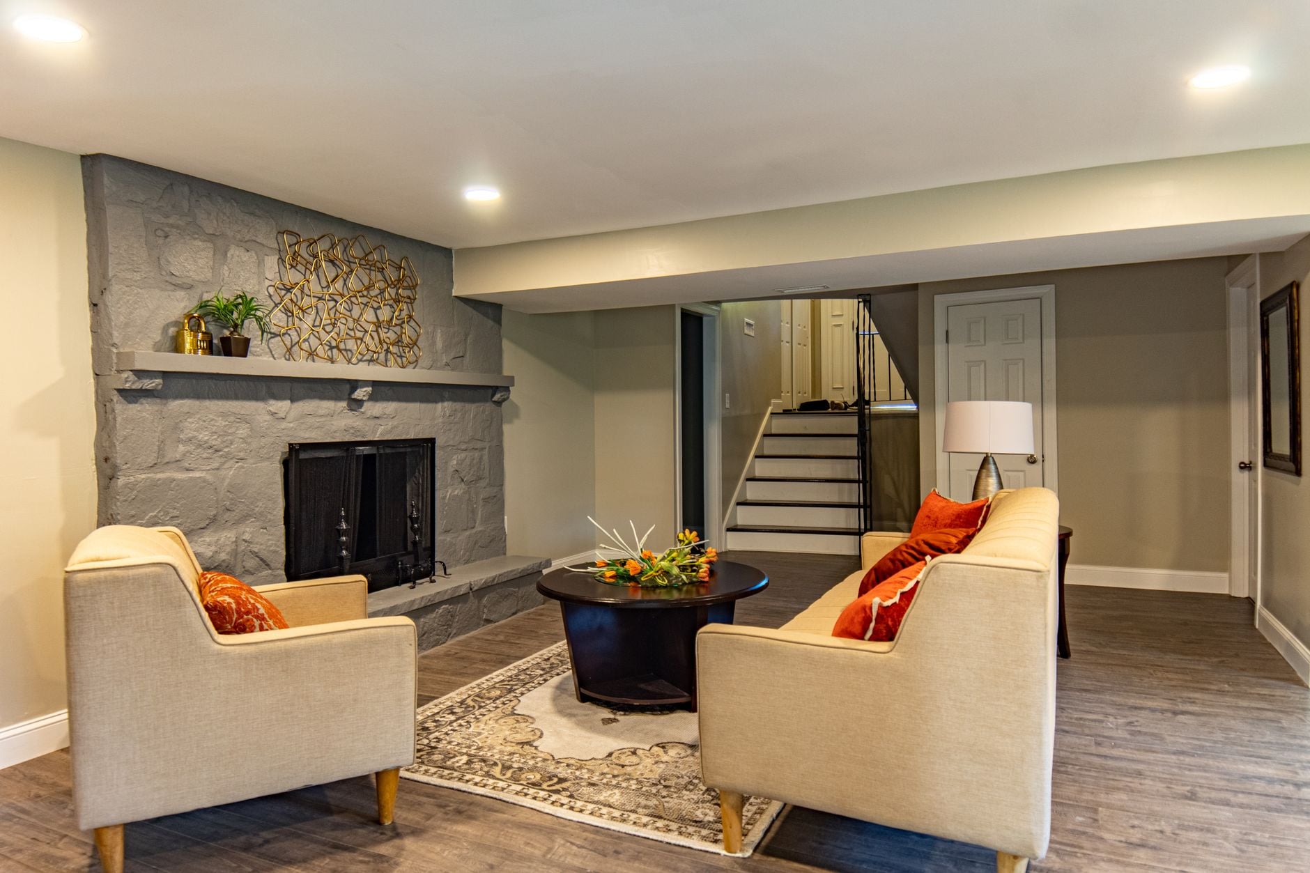 Inviting living room featuring a stone fireplace, beige sofas, and modern decor elements.