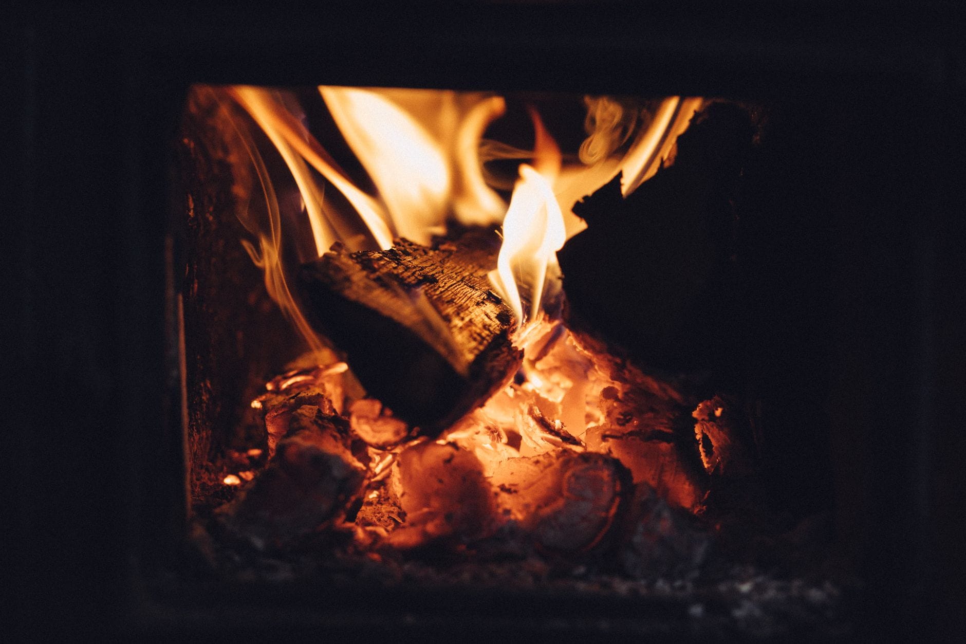 Intimate view of burning firewood emitting warmth in a fireplace. Ideal for cozy home scenes.